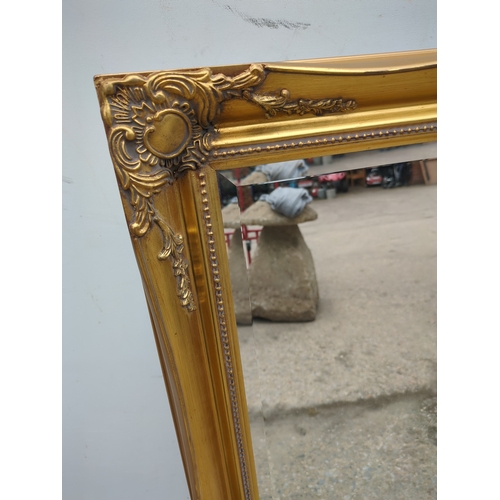 612 - A Bevelled edge wall hanging mirror in an ornate Gold Gilt frame