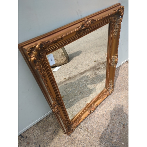 618 - A wall hanging mirror in an ornate Gold Gilt frame