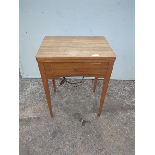 719 - A vintage Singer sewing machine in sewing table