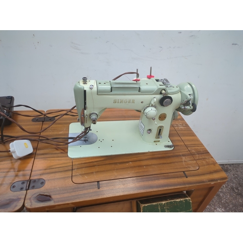 719 - A vintage Singer sewing machine in sewing table