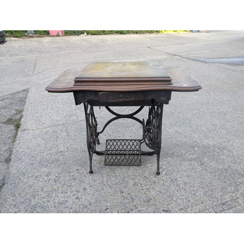 722 - An antique sewing machine in wrought iron table