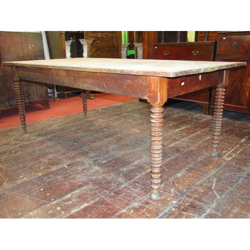 1512 - A 19th century elm farmhouse kitchen table,the plank top raised on four turned tapering bobbin suppo... 