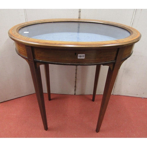 1517 - An Edwardian mahogany vitrine of oval form with plate glass top raised on four square taper supports... 