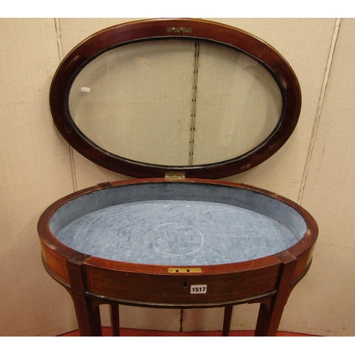 1517 - An Edwardian mahogany vitrine of oval form with plate glass top raised on four square taper supports... 