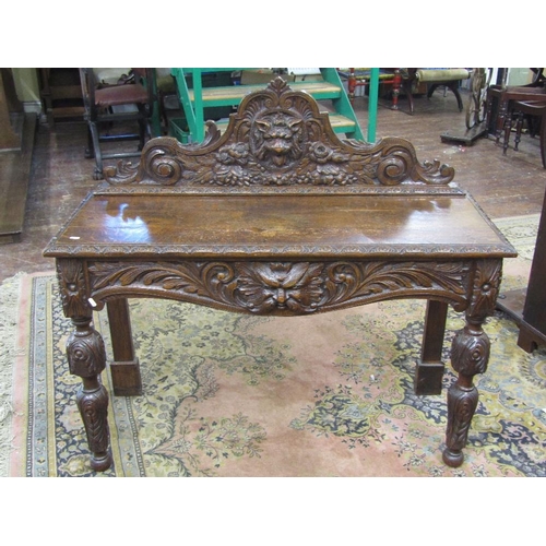 1543 - A Victorian oak hall table of narrow rectangular form with heavily carved detail,including mask,acan... 