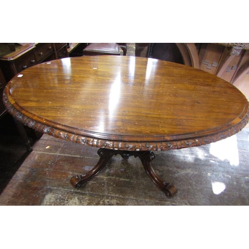 1551 - An early Victorian rosewood loo table,the top of oval form with carved and repeating floral borders ... 