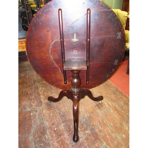 1553 - A large Georgian mahogany snap top table,the circular top 110 cm diameter raised on a vase shaped pi... 