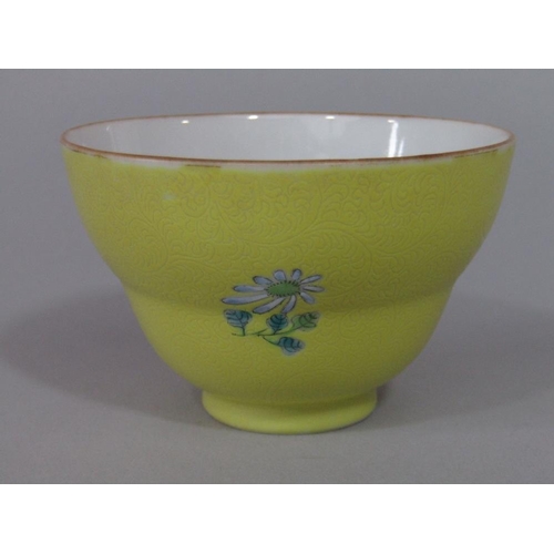 70 - A good quality oriental tea bowl of shaped form with enamelled floral sprigs on a yellow ground with... 