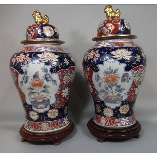 75 - Large pair of Chinese Imari porcelain lidded baluster vases decorated with floral panels,the lids mo... 