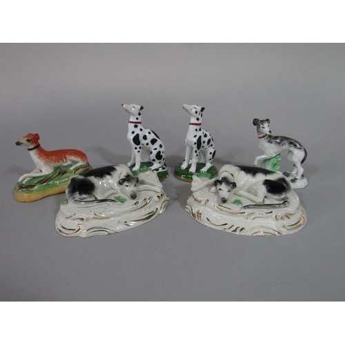 85 - A pair of 19th century Staffordshire models of recumbent black and white greyhounds raised on oval b... 