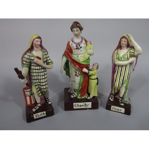 86 - A set of three early 19th century Staffordshire figures representing Faith,Hope and Charity,all rais... 