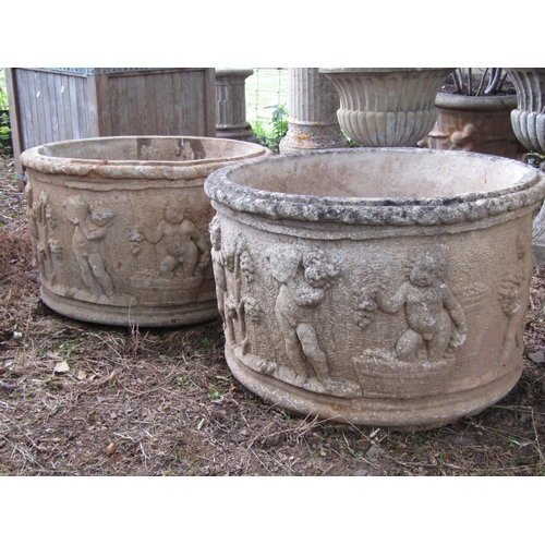 87 - A pair of weathered reconstituted planters with dancing cherub frieze, 60cm high