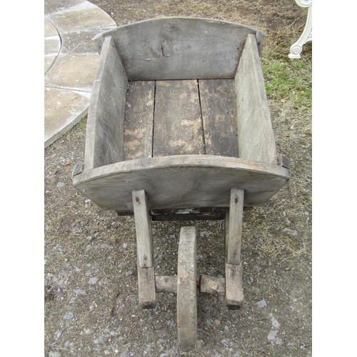 160 - A antique traditional English wheelbarrow in elm, with solid wheel