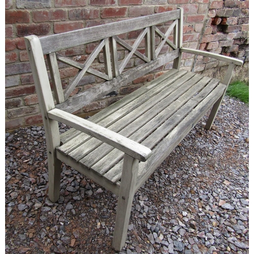 161 - A weathered teak wood garden bench with triple X shaped splats, 150cm long