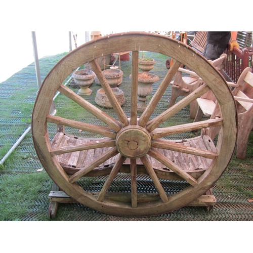 196 - A rustic weathered farmyard seat with wagon wheel back, to seat two, 140cm wide