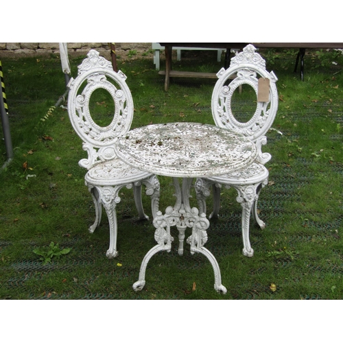 202 - A small decorative cast aluminium terrace table and two matching chairs, the table 60cm diameter