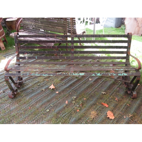 209 - A vintage sprung steel bench on scrolled supports, 182cm long