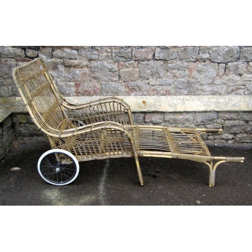 1667 - A vintage wicker portable chaise/lounger with down swept arms, wire spoke wheels and hard rubber tyr... 