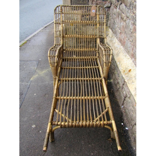 1667 - A vintage wicker portable chaise/lounger with down swept arms, wire spoke wheels and hard rubber tyr... 