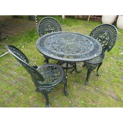 1672 - A green painted aluminium garden terrace table of circular form with decorative pierced detail, toge... 