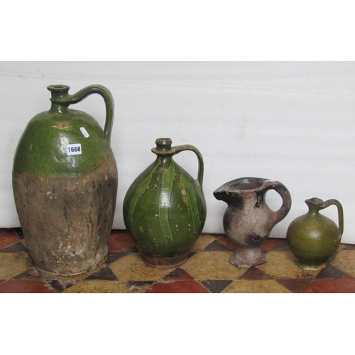 1688 - An old stoneware flagon with partial green glazed loop handle and neck, two further smaller examples... 