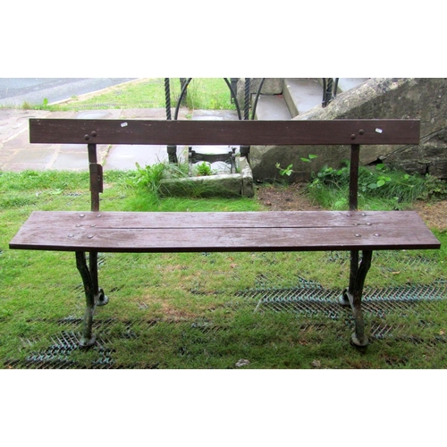 1664 - An old platform type bench with stained two plank wooden seat and back rail raised on cast iron supp... 