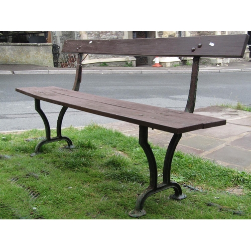 1664 - An old platform type bench with stained two plank wooden seat and back rail raised on cast iron supp... 