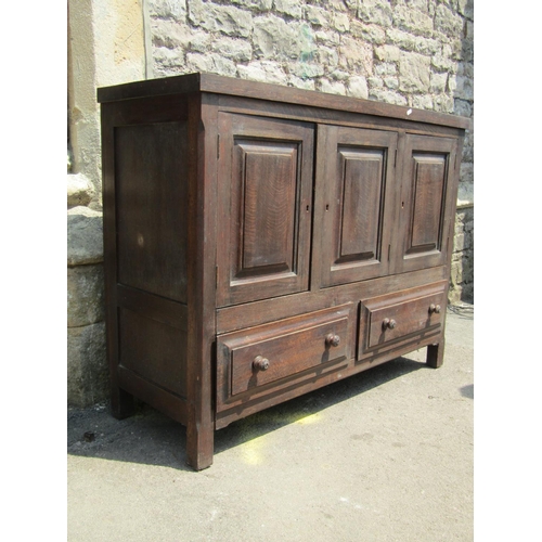 1788 - An Old English style low oak side cupboard partially enclosed by three fielded panelled doors over t... 