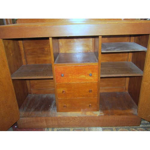 1775 - A medium to light oak side cupboard in the Heals manner, enclosed by a pair of segmented veneered pa... 