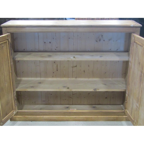 1856 - A stripped pine low side cupboard enclosed by a pair of twin rectangular panelled doors with two fix... 