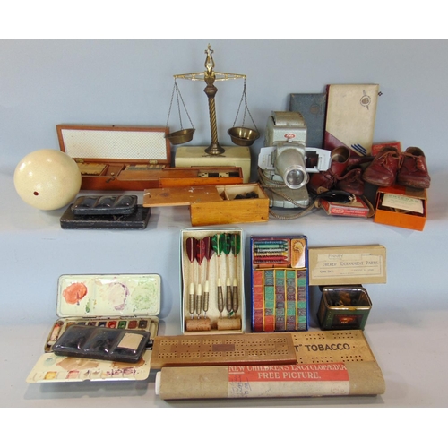 1409 - A box of interesting items comprising various gaming items, darts, etc, set of postal scales, dolls ... 