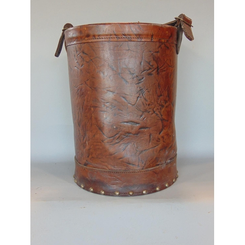 1444 - A studded leather fire bucket containing a large collection of horse brasses