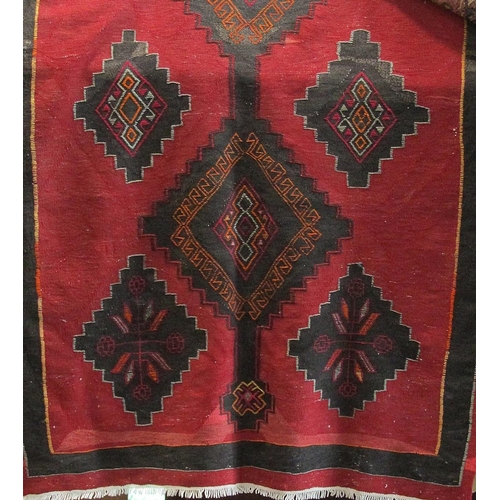 2411 - A Kelim carpet or runner with black panelled floral decoration upon a red ground, 390 x 160cm