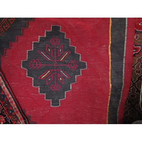 2411 - A Kelim carpet or runner with black panelled floral decoration upon a red ground, 390 x 160cm