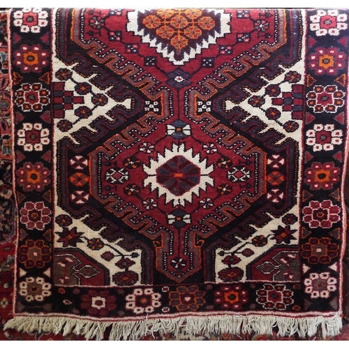 2385 - Good quality full pile Heriz runner,with various colourful medallions upon a red ground,325 x 110cm