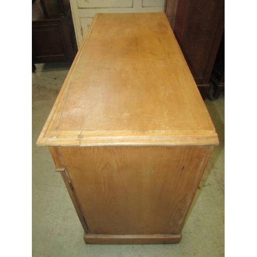 1864 - A Victorian stripped pine dresser fitted with three frieze drawers over a pair of cupboards flanking... 