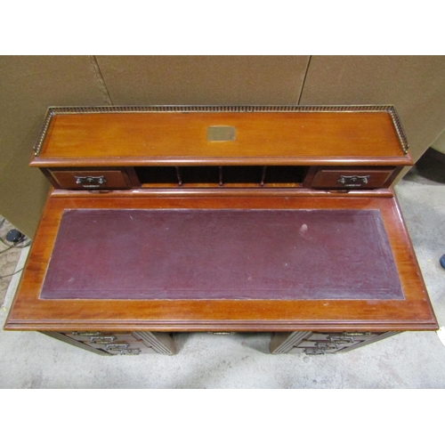 1874 - An Edwardian walnut kneehole twin pedestal writing desk fitted with an arrangement of nine drawers, ... 