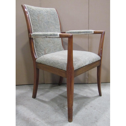 1911 - A pair of mid-20th century teak framed open armchairs, with floral patterned upholstered seats, swep... 