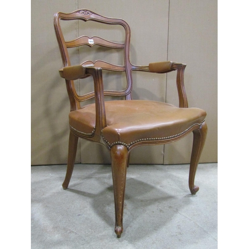 1912 - An oak open elbow chair, the moulded frame with shield shaped ladder-back, raised on scrolled cabrio... 