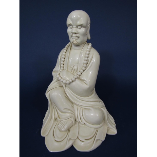 676 - A large cream glazed oriental figure of a Lohan in seated pose with impressed seal mark to reverse, ... 