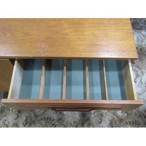 1937 - A long and low retro teak sideboard, partially enclosed by three doors and a tower of three drawers,... 