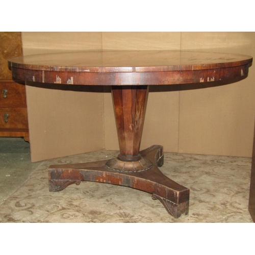 1942 - A 19th century rosewood veneered loo table of circular form, raised on an inverted octagonal pillar ... 