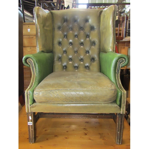 1954 - A Georgian style two tone green leather upholstered wing armchair with buttoned back, loose seat cus... 