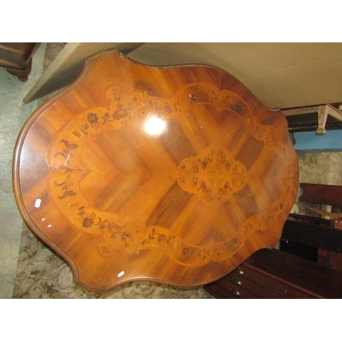 1956 - A reproduction Italian dining or centre table, with inlaid foliate detail and serpentine moulded out... 