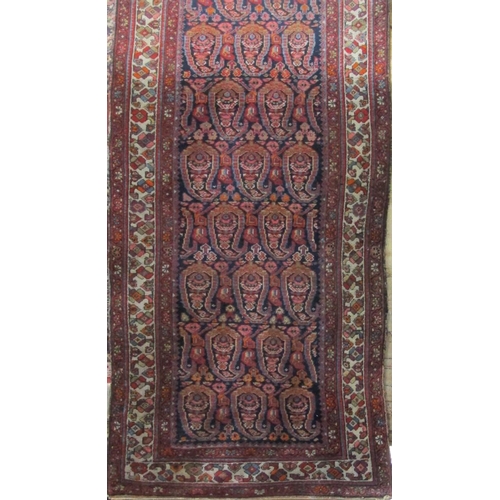 2372 - A good long Persian runner with geometric paisley decoration upon a blue and red ground, 500 x 100cm