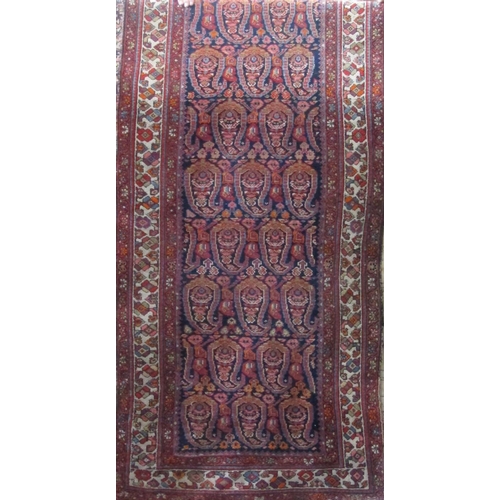 2372 - A good long Persian runner with geometric paisley decoration upon a blue and red ground, 500 x 100cm