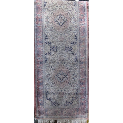 2374 - Cashmere type runner decorated with various floral medallions upon a pink ground, 300 x 80cm