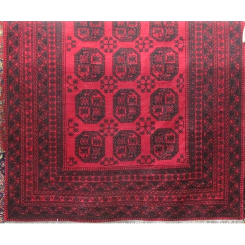 2379 - A good quality Bokhara carpet with typical geometric medallion decoration upon a deep red ground, 28... 