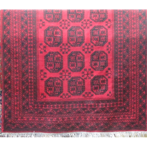 2379 - A good quality Bokhara carpet with typical geometric medallion decoration upon a deep red ground, 28... 