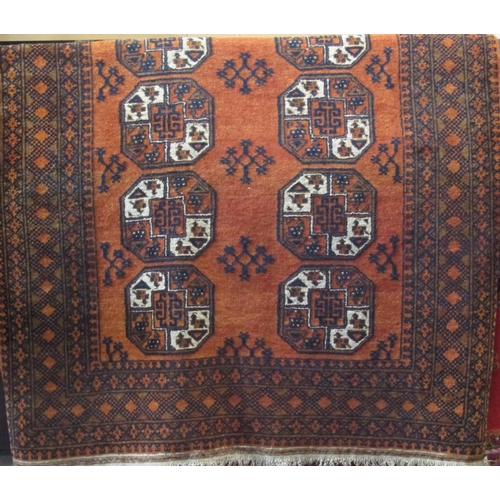 2389 - Full pile Bokhara carpet with typical geometric medallion decoration upon a burnt orange ground, 210... 